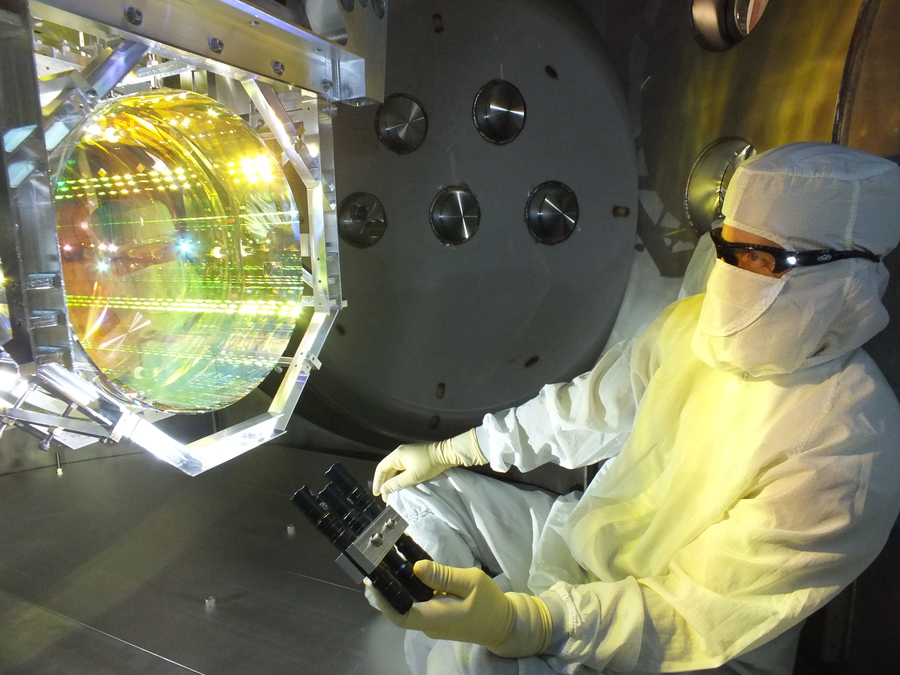 LIGO optics technician inspecting mirror coating surface